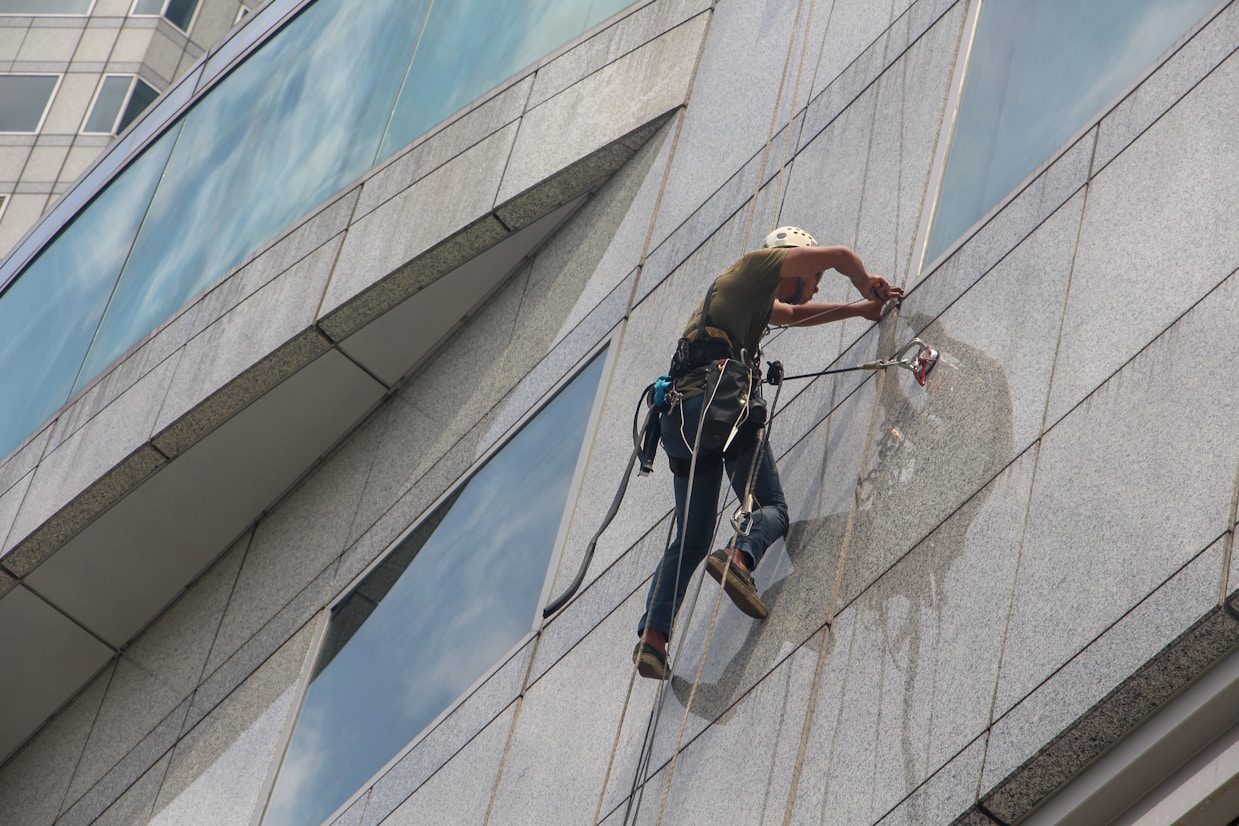 Professional glass installation specialist working on commercial building facade